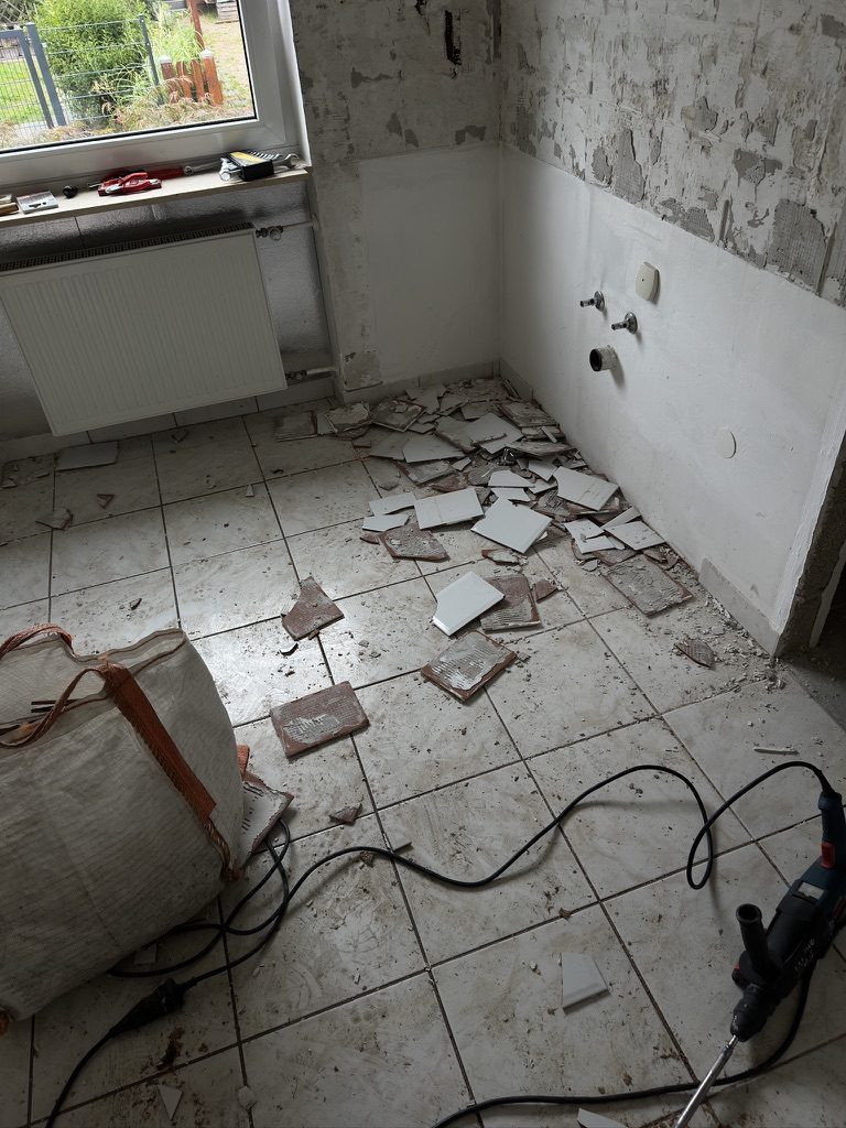 Badezimmer während der Entkernung, die Wandfliesen sind bereits abgeschlagen