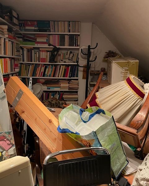 Dachzimmer voller Bücher, Kartons und Möbel vor der Wohnungsauflösung